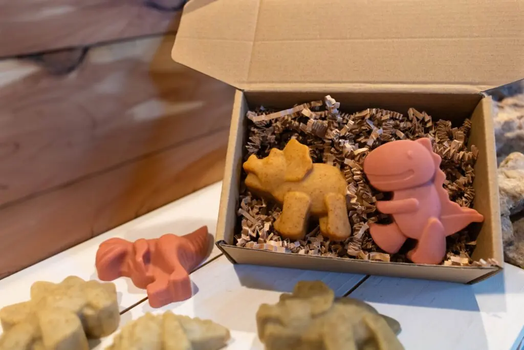 Handmade dinosaur-shaped soap set in a packaging box with crinkle paper