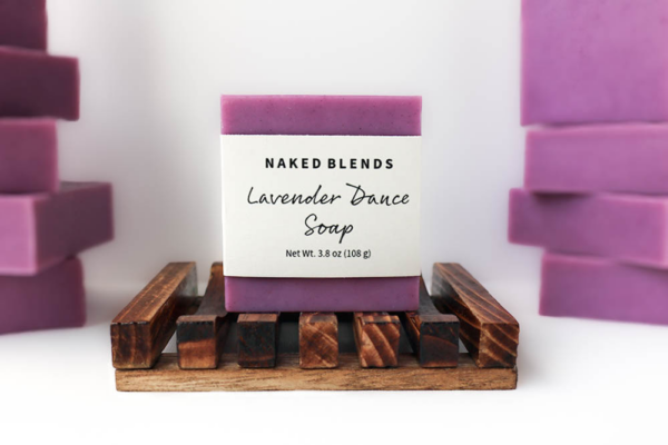Lavender Dance Soap, labeled and resting on a wooden soap dish in