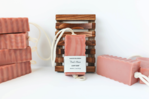 Pink Haze Loop Soap with the label and other soaps around it with a Wooden Soap Dish